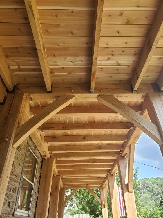 A wooden porch with beams and rafters.