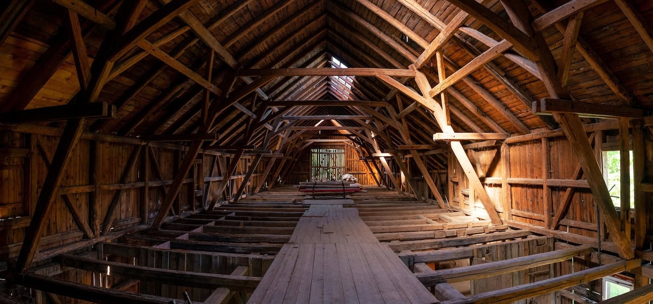 Interior of large old timber frame barn in Germany during renovation, upper floor wide angle shot